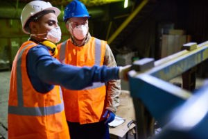 two factory workers working together