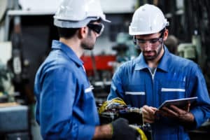 Two men engineer talking in modern factory. Production line machine and setting it for work.