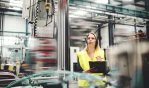 An industrial woman engineer with headset in a factory, working. Copy space.