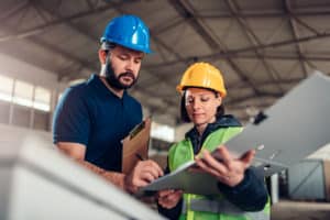 Factory worker signing document in industrial hall