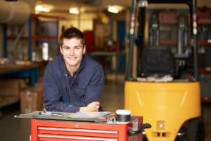 Portrait Of Apprentice Engineer In Factory Smiling At Camera