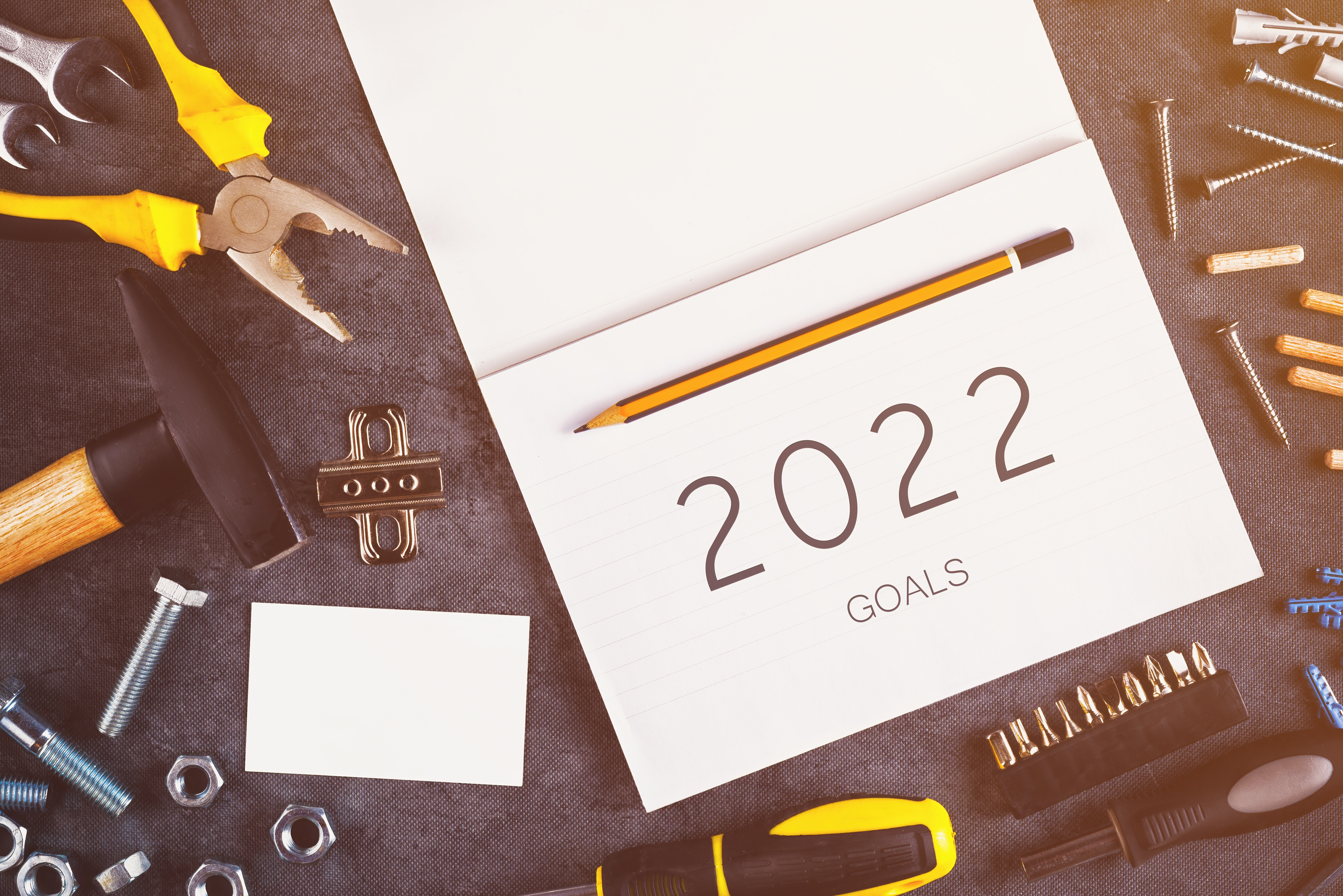 2022 Goals, assorted Do It Yourself DIY tools and notebook on desk in workshop