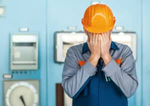 Portrait of stressed despair engineer closed face by two hands